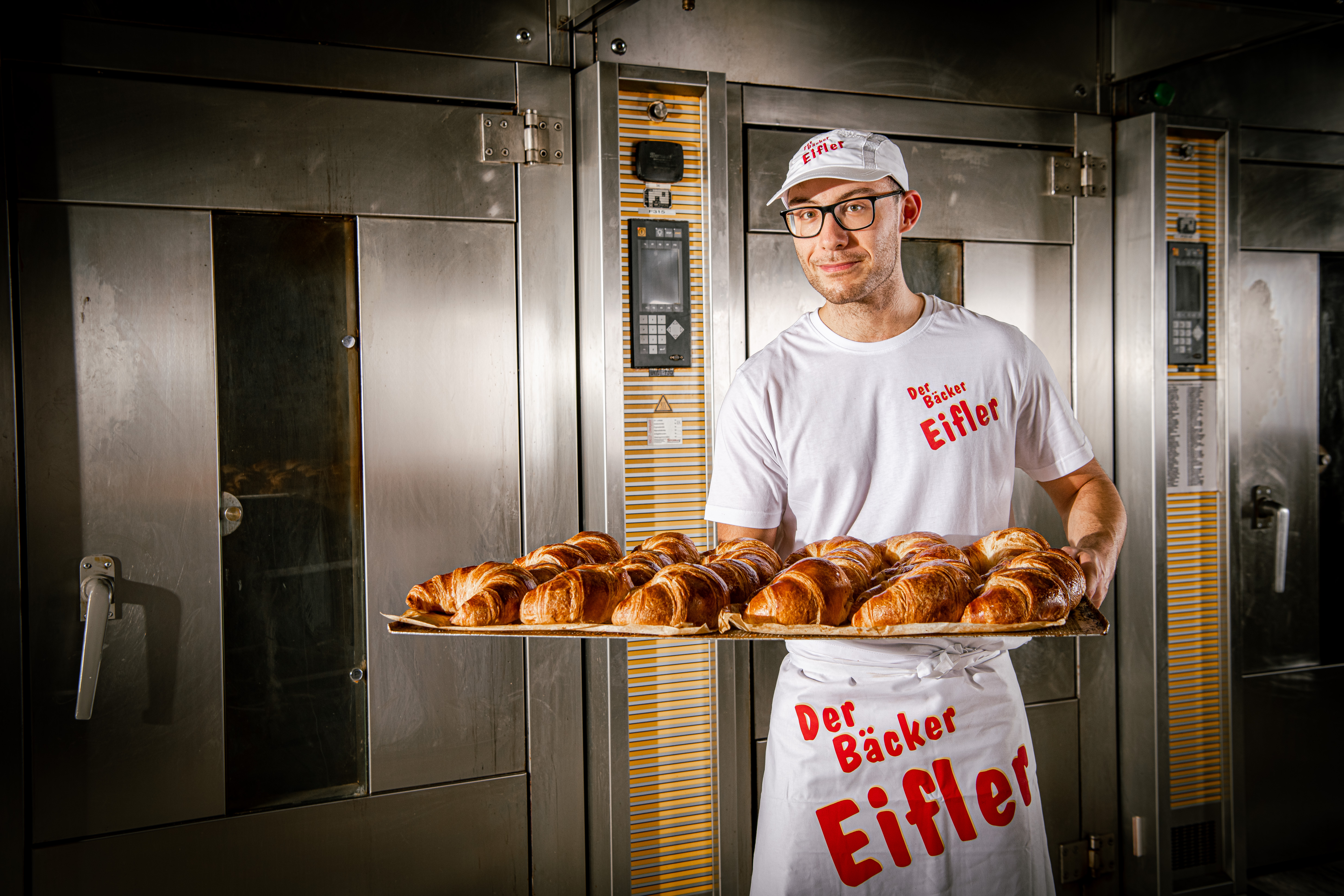 Der Bäcker Eifler Bäcker zeigt frisch gebackene Croissants