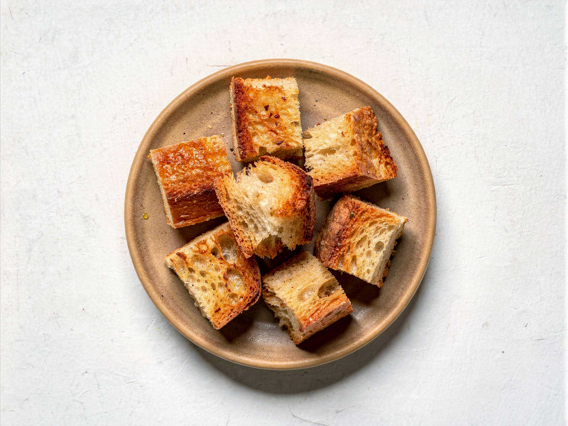 Knusprige Croûtons aus geröstetem Brot, goldbraun gebacken – ideal als Topping oder zum Dippen.