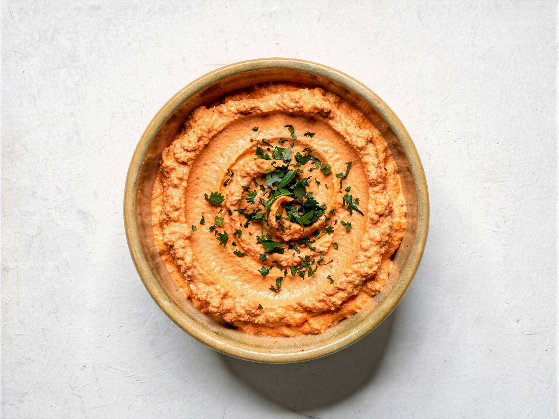 Cremiger Feta-Paprika-Dip in einer Schale, glatt gerührt mit feiner Spiralstruktur – ideal als Aufstrich oder Begleiter zu frischem Brot.